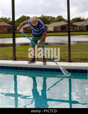 Reifer Mann tun Poolpflege zu seinem Florida Pool Zuhause, 25. April 2016 Stockfoto