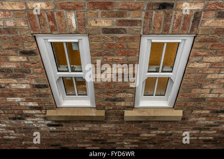 Zwei Fenster im Badezimmer an der Seitenwand des Hauses, von außen gesehen Stockfoto