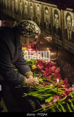 Slavutych, Kiew, Ukraine. 26. April 2016. Frau legt eine Kerze in der Gedenkstätte zu Chernobyl Feuerwehrleute in Slavutych, Ukraine, während der Zeremonie den 30. Jahrestag der Reaktorkatastrophe von Tschernobyl. Slawutytsch ist eine Stadt im Norden der Ukraine waren die meisten Beschäftigten der Chernobyl Atomkraftwerk wurden nach der Katastrophe verlagert. © Celestino Arce/ZUMA Draht/Alamy Live-Nachrichten Stockfoto