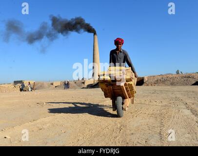 Kandahar, Afghanistan. 26. April 2016. Ein afghanischer Mann schiebt einen Handwagen auf eine Ziegelei in der Provinz Kandahar, Süden Afghanistans, 26. April 2016. Es gibt Dutzende von gemauerten Öfen von Einheimischen im Vorort der Stadt Kandahar geführt. Der Betrieb von Ziegeleien haben Tausende von Menschen hier als die meisten Brennöfen nutzlos Reifen und Kohle, was negative Auswirkungen auf die Umwelt nach lokalen Beamten betroffen. © Sanaullah Seiam/Xinhua/Alamy Live-Nachrichten Stockfoto
