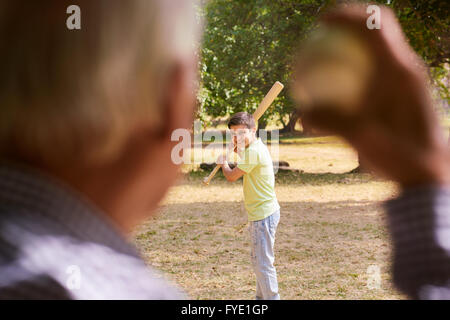 Großeltern mit Enkel: Senior Woman spielen Baseball mit seinem Enkel im Park. Das junge Kind hält auf Anhieb, wh Stockfoto