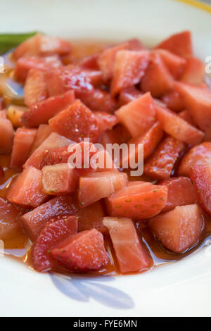 geschnittene Erdbeeren in eine Schüssel, gewürzt mit einer vinaigrette Stockfoto