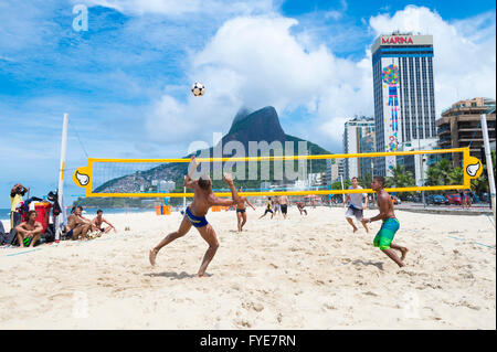 RIO DE JANEIRO - 17. März 2016: Brasilianer spielen Sie eine Partie Futevolei (Footvolley), ein Sport, der Fußball und Volleyball verbindet Stockfoto