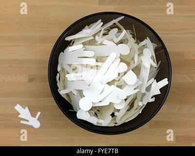 Ein Papierkorb mit Menschen Ausschnitte isoliert auf einem Holzfußboden Stockfoto