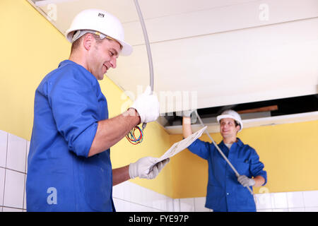 Zwei Elektriker in einem Raum im Bau Stockfoto