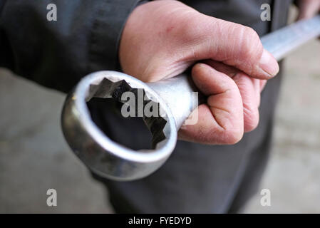 männliche Kfz-Mechaniker hält großen Ringschlüssel Stockfoto