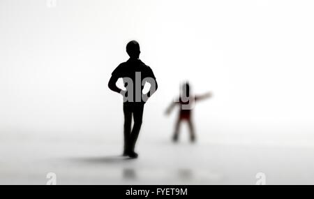 Eine junge Kind Kind Silhouette auszustrecken um Hilfe, gefolgt von einem unbekannten fremden Stockfoto