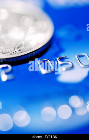 blaue Kreditkarte mit einer Münze Stockfoto