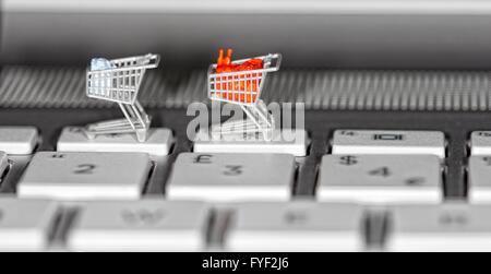 Supermarkt-Einkaufswagen auf einer Laptoptastatur hautnah. Stockfoto