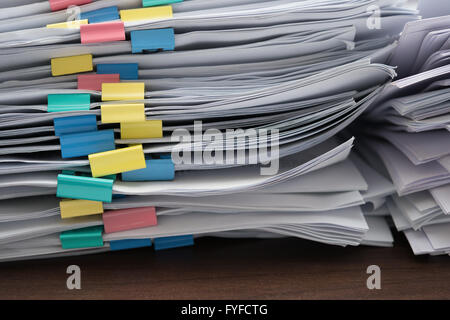 zwei Stapel von Dokumenten mit bunten Clips auf Schreibtisch stapeln Stockfoto