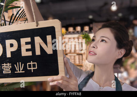 Tee-Hauseigentümer aufstellen Schild "geöffnet" Stockfoto