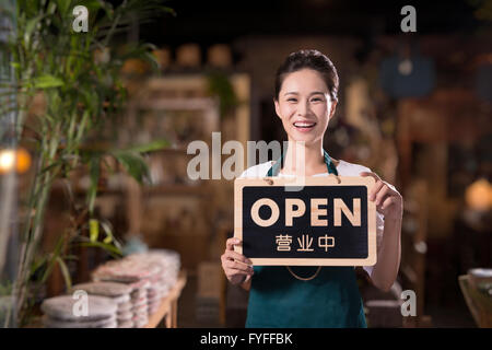 Tee Hauseigentümer halten Schild "geöffnet" Stockfoto