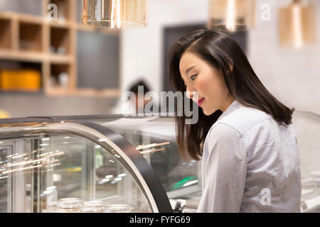 Ladenbesitzer vor Vitrine in Bäckerei Stockfoto