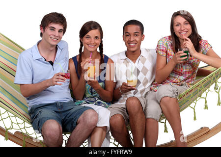 Eine Gruppe von Freunden Cocktails auf einer Hängematte genießen. Stockfoto