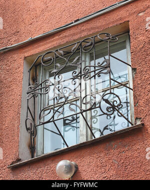 Metall geschmiedet geschnitzten Gitter auf eine weiße Kunststoff-Fenster Stockfoto