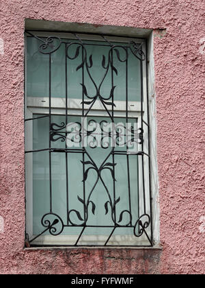 Schwarz Metall geschmiedet geschnitzten Gitter in ein weißes Fenster Stockfoto