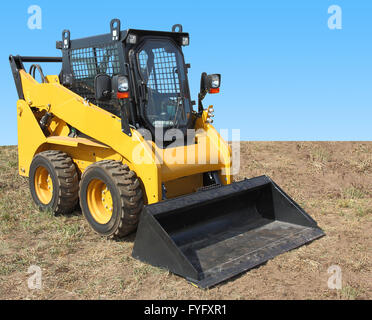 Die gelben Truck mit einem Schaber, Ladung zu heben. Stockfoto