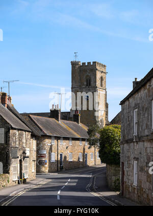 Blick entlang der Hauptstraße in Abbotsbury mit der Kirche des Heiligen Nikolaus im Hintergrund Stockfoto