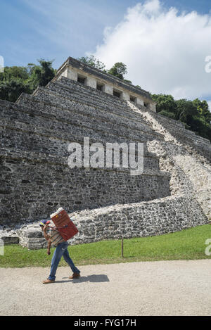 CHIAPAS, PALENQUE, Mexiko – 1. März 2016: Handwerker vor Ort trägt seine schwere Kiste von Kunsthandwerk über archäologische Stätte Palenque. Stockfoto