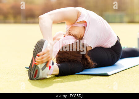 Flexible Mädchen tun stretching auf Fitness-Matte. Sportliche Mädchen Schönheit ihrer Beine nach dem Training Stockfoto