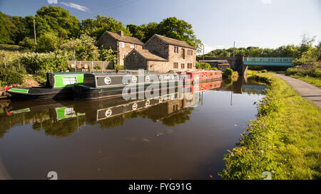 Narrowboats festgemacht an der Leeds and Liverpool Canal neben einem Bauernhaus im Aire Valley. Stockfoto