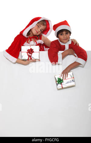 Bruder und Schwester in Weihnachtsmann Outfits gekleidet Stockfoto