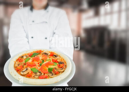 Zusammengesetztes Bild der Küchenchef hält leckere pizza Stockfoto