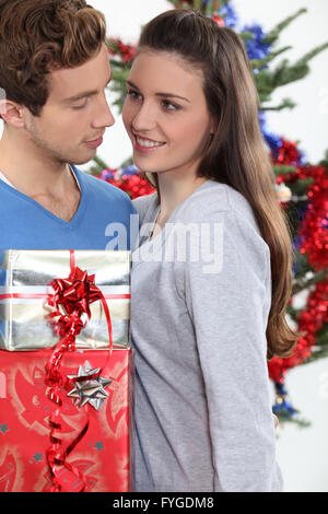 Junger Mann seine Freundin zu Weihnachten Geschenk anzubieten Stockfoto