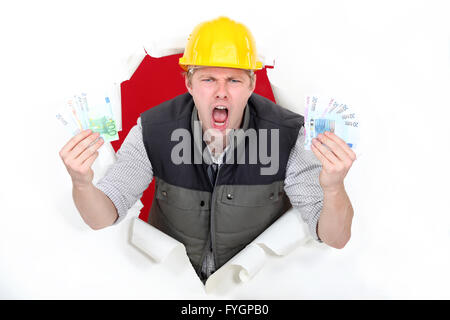 Ein männlicher Bauarbeiter mit viel Geld. Stockfoto