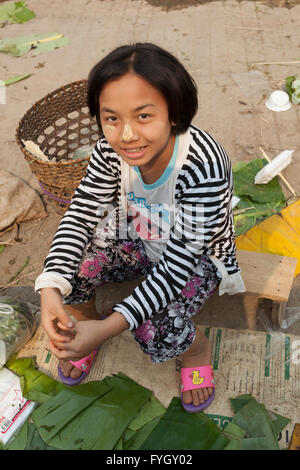 Junge Dame mit traditionellen Make-up bei Obst und Gemüse für den Verkauf in einem Straßenmarkt in Myanmar (Burma) Stockfoto