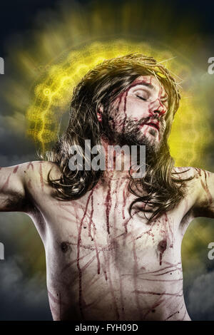 Jesus Christus mit einem Heiligenschein aus goldenem Licht am Kreuz Stockfoto