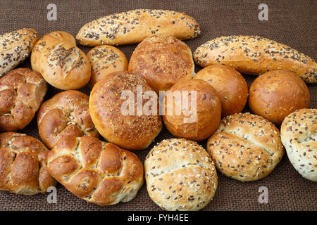 Verschiedene Arten von Vollkorn Brot und Brötchen auf braunem Hintergrund Stockfoto