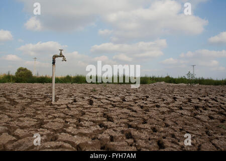 Umweltkonzept, Wasserknappheit und Dürre trockene rissige Schlamm mit einem Wasserhahn Stockfoto