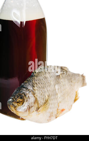 Eine Flasche einheimisches Bier und getrocknetem Fisch ist isoliert auf weiß Stockfoto