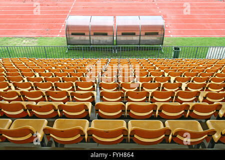 Trainer und Reserve Bänke mit gelben Sitze im Fußballstadion wieder Perspektive Stockfoto