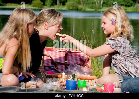 Junges Mädchen füttert die Mutter Stockfoto