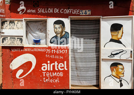 BURKINA FASO, Kaya, Friseur mit Schildern verschiedene Abschläge als Werbung und Anzeige der indischen Mobilfunkunternehmen Airtel anzeigen Stockfoto