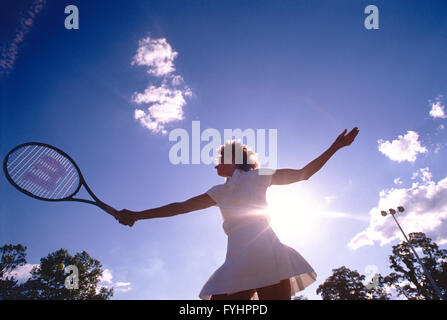 Tennisspielerin, die den Ball mit einem Schläger Stockfoto