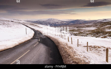 Reiten auf Hawes am Buttertubs-Pass in den Yorkshire Dales. Die 2-spurige Straße schlängelt sich über den tief verschneiten Mauren im Winter. Stockfoto