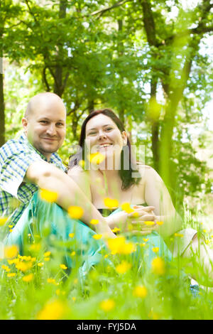 Glückliche junge Ehepaar zwischen Blumen Stockfoto