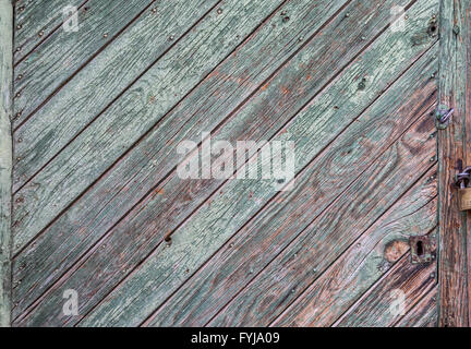 Grüne Farbe peeling aus einer Holzplatte Tür zeigt die Maserung des Holzes und alte braun lackierten Oberfläche Stockfoto