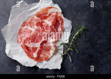 Schinkenscheiben auf Papier über Stein Hintergrund. Draufsicht mit Textfreiraum Stockfoto