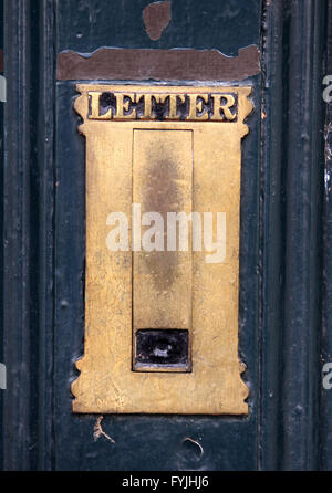 Alte Messing-Briefkasten in einer blauen Tür mit abblätternde Farbe. Stockfoto