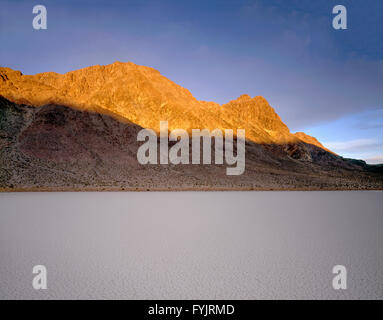 USA, Kalifornien, Death Valley Nationalpark, Sunrise auf Ubehebe Gipfel über trockenen Seebett oder Playa genannt The Racetrack. Stockfoto