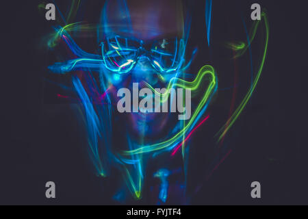 Bewegung, Effekt Lightpainting Mann mit Sonnenbrille und bunten Lichtern Stockfoto