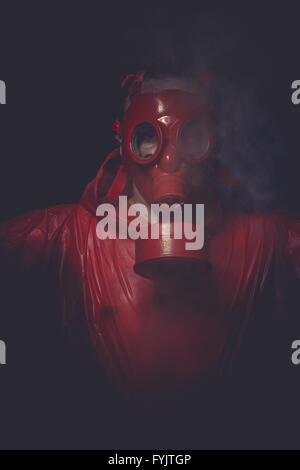Problem, ein Mann in eine Gasmaske über den Rauch. schwarzen Hintergrund und roten Farben Stockfoto