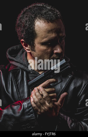 Rob, Dieb mit Pistole in der hand. Mann in Lederjacke Stockfoto