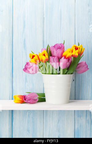 Frische Bunte Tulpen Blumenstrauß auf Regal vor Holzwand. Zeigen mit textfreiraum an Stockfoto