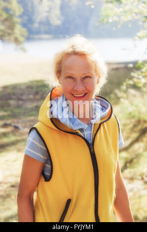 Porträt einer Frau mittleren Alters in einem Park an einem sonnigen Tag Stockfoto