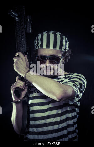 Revolte, Gefangene in einem Gefängnis mit einem Maschinengewehr Stockfoto
